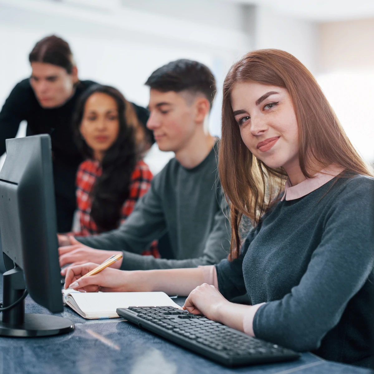 woman working with colleagues on a PC